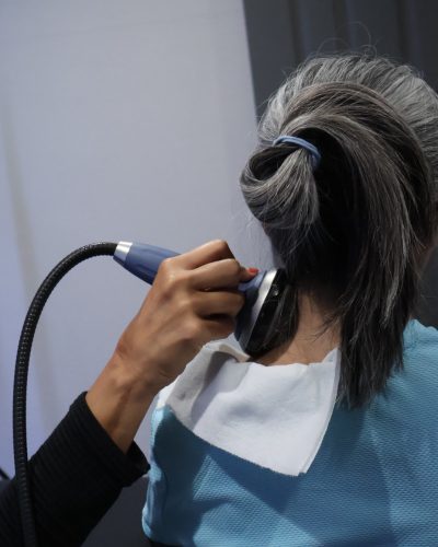 Shockwave therapy applied to upper neck for pain relief.